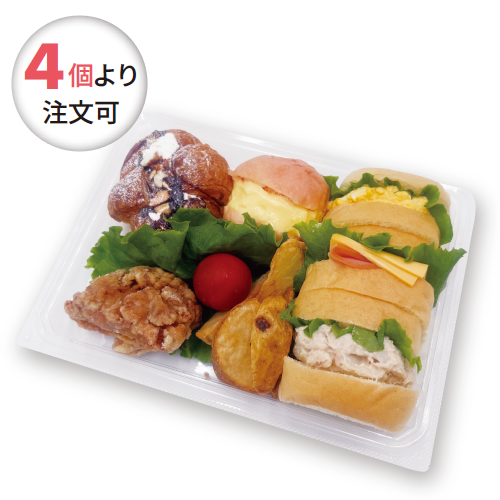 Assorted takeaway bento: fried chicken, croissant-style sandwich, egg sandwiches, greens, and a cherry tomato. Circular badge says '4個より 注文可'.